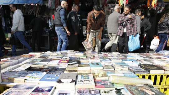 Books are displayed on a pavement in downtown Amman
